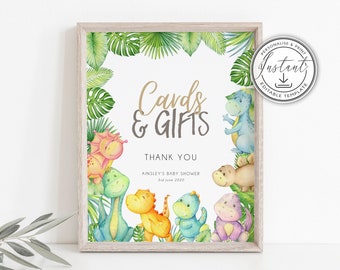 May include: A printable sign with a jungle theme for a baby shower. The sign says "Cards & Gifts" and "Thank You" with the date and name of the baby shower. The sign is decorated with colourful cartoon dinosaurs and tropical leaves.