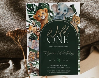 May include: A green and gold jungle-themed first birthday party invitation with a circle in the center that says "Wild One". The invitation includes the text "Please join us to celebrate Flynn's 1st birthday" and details about the party, including the date, time, location, and contact information.