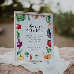 May include: A white sign with a watercolor illustration of vegetables and the text "baby ADVICE" in black script. The sign also includes the text "PLEASE LEAVE YOUR ADVICE AND WELL WISHES FOR THE PARENTS-TO-BE" and "AINSLEY'S BABY SHOWER 3 AUGUST 2022".