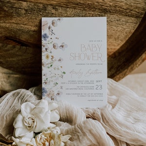 May include: A baby shower invitation with a floral design in shades of blue, pink, and green. The invitation features the text "Join us for a Baby Shower" and "Honoring the Mommy-to-be" with the name "Ainsley Smithson". The date and time of the shower are listed as "Saturday, August 23rd, 20XX from 1-4 o'clock in the afternoon". The location is listed as "The Smithson Home, 100 Wantirna Road, California".
