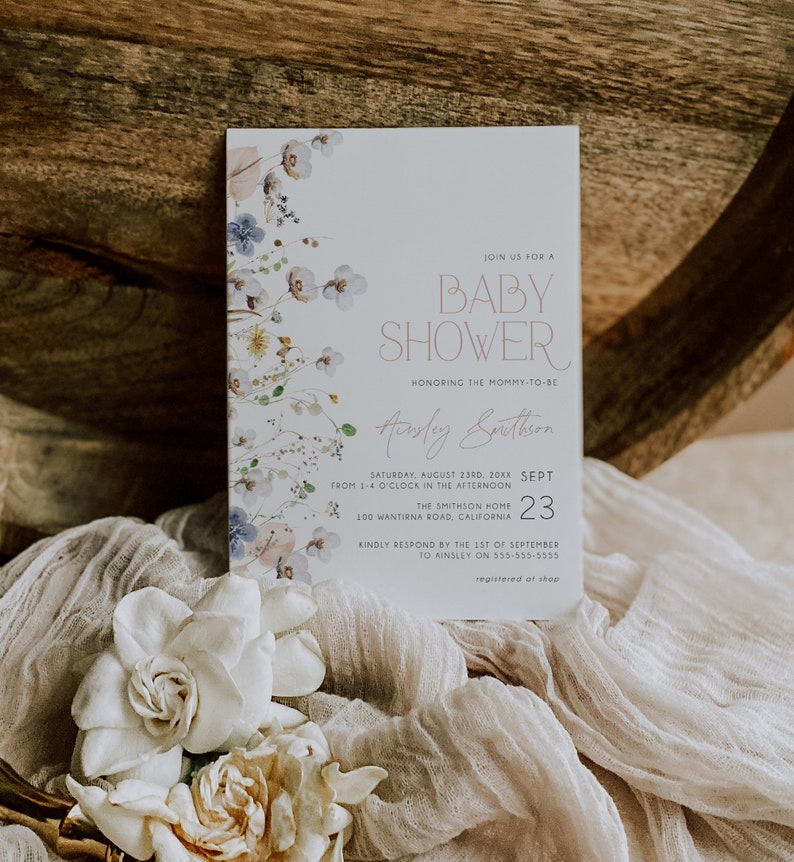 May include: A baby shower invitation with a floral design in shades of blue, pink, and green. The invitation features the text "Join us for a Baby Shower" and "Honoring the Mommy-to-be" with the name "Ainsley Smithson". The date and time of the shower are listed as "Saturday, August 23rd, 20XX from 1-4 o'clock in the afternoon". The location is listed as "The Smithson Home, 100 Wantirna Road, California".