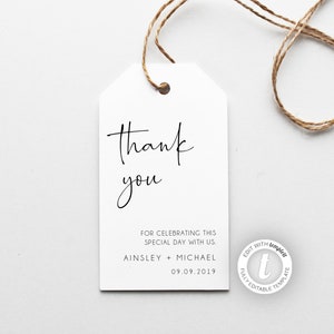 May include: White thank you tag with black calligraphy that reads "Thank you" and the text "FOR CELEBRATING THIS SPECIAL DAY WITH US. AINSLEY + MICHAEL 09.09.2019". The tag is tied with twine.