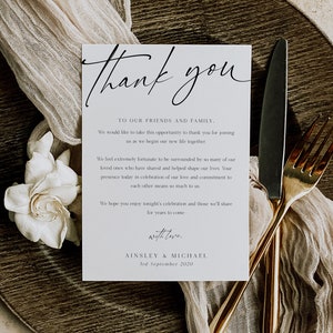 May include: A white thank you card with black calligraphy that reads "Thank you". The card has a simple design with the text "To our friends and family" and a message expressing gratitude for joining the couple as they begin their new life together. The card is signed "Ainsley & Michael" and dated "3rd September 2020".