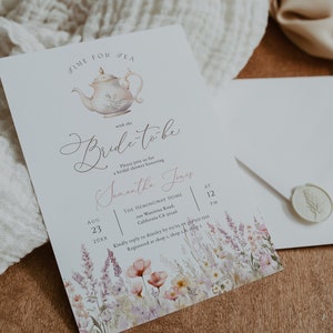 May include: A white tea party invitation with a watercolor illustration of a teapot and floral accents. The invitation reads "Time for Tea with the Bride-to-be Samantha Jones" and includes the date, time, and location of the event.