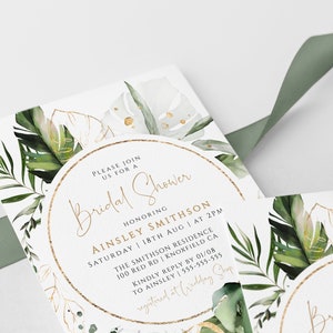 Op de afbeelding: Een witte kaart met gouden rand en groene aquarelbladeren. De tekst op de kaart luidt "U bent van harte welkom voor een Bridal Shower ter ere van Ainsley Smithson Zaterdag 18 augustus om 14:00 uur The Smithson Residence 100 Red Rd Knoxfield CA Graag uw antwoord v&oacute;&oacute;r 01/08 aan Ainsley op 555-555-555 geregistreerd bij Wedding Shop"
