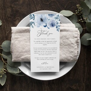 Puede incluir: Una tarjeta de agradecimiento de boda floral azul y blanca con el texto "Gracias" en una fuente de escritura. La tarjeta tambi&eacute;n incluye el texto "A nuestros amigos y familia" y "Ainsley & Michael" con la fecha "3 de septiembre de 2020".