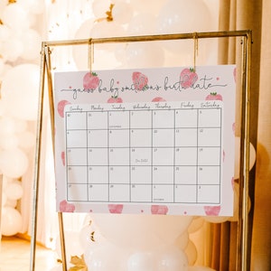 Puede incluir: Un calendario rosa y blanco con un patr&oacute;n de fresas. El calendario est&aacute; titulado "Adivina la fecha de nacimiento del beb&eacute; Smithson" y tiene los meses de septiembre y octubre listados. La fecha de parto est&aacute; marcada el 23 de septiembre.