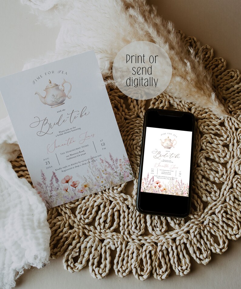 May include: A blue and white teacup with a floral design is featured on a light blue invitation with the text "Time for Tea with the Bride-to-be Samantha Jones" and details for a bridal shower. The invitation is printed on a white background with a floral design. The invitation is displayed on a woven straw mat with a smartphone showing a similar invitation.