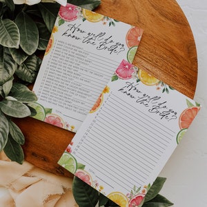 Peut inclure: Deux cartes de jeu imprimables sur le th&egrave;me des agrumes. Les cartes pr&eacute;sentent un motif floral avec des citrons, des limes et des pamplemousses. Le texte sur les cartes indique "How well do you know the bride?" et comprend une liste de questions sur la mari&eacute;e.