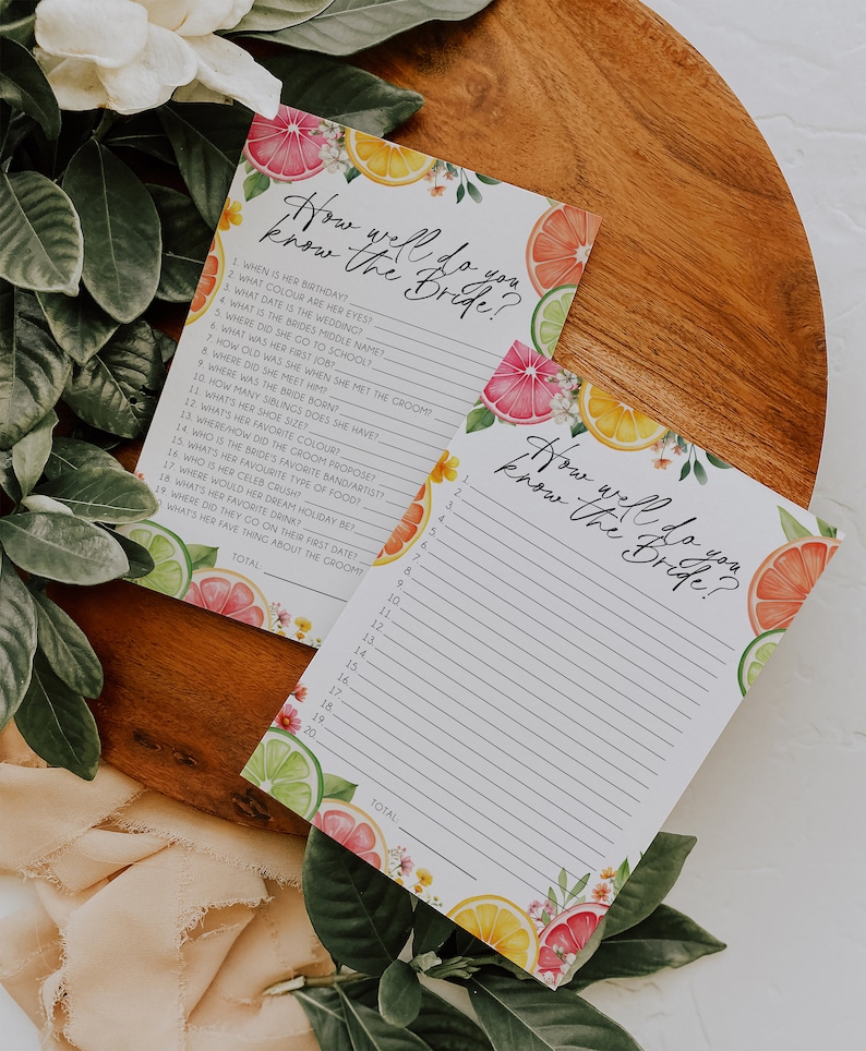 Peut inclure: Deux cartes de jeu imprimables sur le th&egrave;me des agrumes. Les cartes pr&eacute;sentent un motif floral avec des citrons, des limes et des pamplemousses. Le texte sur les cartes indique "How well do you know the bride?" et comprend une liste de questions sur la mari&eacute;e.