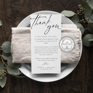 May include: A white thank you card with black text. The card reads "Thank you" in a script font. The text continues with a message to friends and family, expressing gratitude for their presence at the wedding. The card is signed "Ainsley & Michael" and includes the date "3rd September 2020".