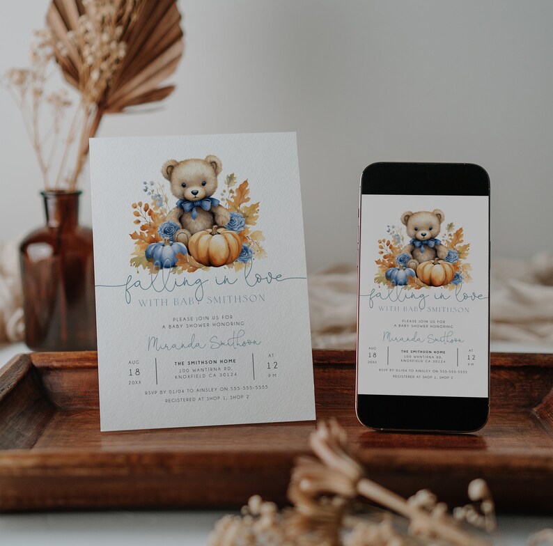 May include: A baby shower invitation with a blue and orange colour scheme. The invitation features a cartoon bear holding a pumpkin and surrounded by autumn leaves. The text on the invitation reads "falling in love with baby Smithson".