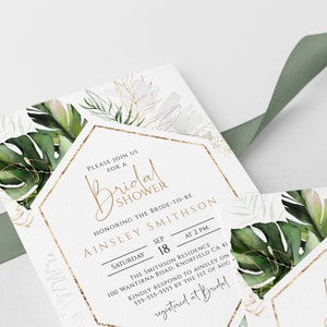 Puede incluir: Una invitaci&oacute;n blanca con detalles dorados y hojas tropicales verdes. La invitaci&oacute;n es para una despedida de soltera para Ainsley Smithson el s&aacute;bado 18 de septiembre a las 2 PM. La direcci&oacute;n es 100 Wantirna Road, Knoxfield CA 41. Por favor, responde a Ainsley antes del 1 de agosto al 555-555-5555. La invitaci&oacute;n est&aacute; registrada en Bridal.