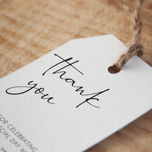 May include: White thank you tag with a handwritten thank you message. The tag is tied with twine and has a hole punched in the top.