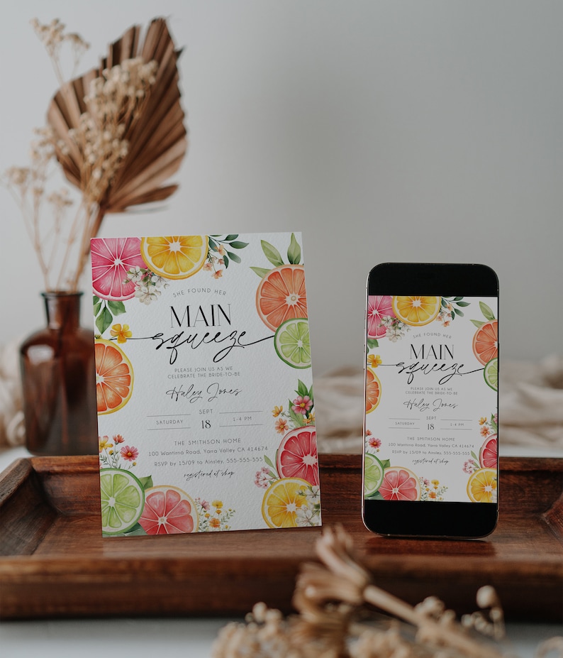 K&ouml;nnte beinhalten: Eine digitale und gedruckte Einladung zu einer Bridal Shower mit einem Zitrus-Thema. Die Einladung zeigt eine Aquarell-Illustration von Zitronen, Limetten und Grapefruits mit wei&szlig;en Bl&uuml;ten. Der Text auf der Einladung lautet "She Found Her Main Squeeze" und enth&auml;lt den Namen der Braut, das Datum, die Uhrzeit und den Ort der Veranstaltung.