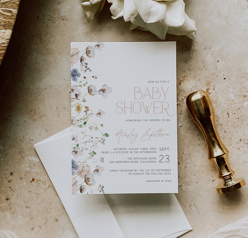 May include: A white baby shower invitation with a floral design in shades of blue, pink, and green. The invitation text reads "Join us for a Baby Shower honoring the mommy-to-be Ainsley Smithson Saturday, August 23rd, 20XX from 1-4 o'clock in the afternoon The Smithson Home 100 Wantirna Road, California 23 Kindly respond by the 1st of September to Ainsley on 555-555-5555 registered at shop"