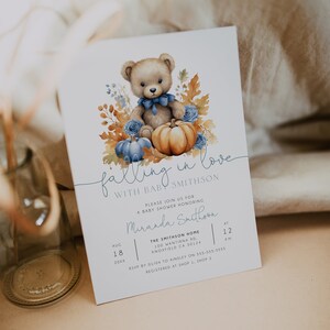 May include: A baby shower invitation featuring a watercolour illustration of a teddy bear holding a pumpkin. The invitation reads "Falling in love with baby Smithson" and includes the date, time, and location of the shower.