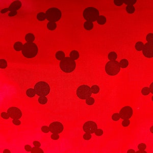 May include: Red fabric with a repeating pattern of black Mickey Mouse heads.