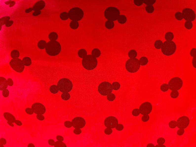 May include: Red fabric with a repeating pattern of black Mickey Mouse heads.