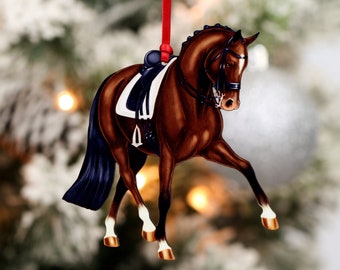 May include: A brown horse with a black tail and white markings is wearing a saddle and bridle. The horse is depicted in a dressage pose, with its head held high and its legs extended. The ornament is made of wood and is painted in a realistic style.