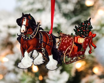 Può includere: Un ornamento natalizio con un cavallo marrone e bianco che tira una slitta rossa con un piccolo albero di Natale e dei regali. L'ornamento è in metallo e ha un nastro rosso per appenderlo.