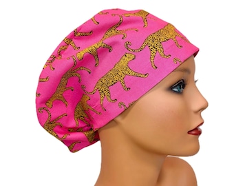 May include: A pink scrub cap featuring a repeating pattern of yellow and black leopard print. The cap is designed to cover the hair and is made of a soft, flexible fabric. The cap is shown on a mannequin.