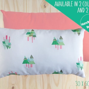 Op de afbeelding: Twee decoratieve kussenhoezen, een roze en een witte met een groen geometrisch boompatroon. De witte kussenhoes heeft de tekst "30 x 50 CM" erop gedrukt. De teksten "AVAILABLE IN 2 COLOURS AND 2 SIZES" en "Handmade Brand" zijn gedrukt op een groene achtergrond.