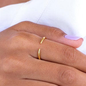 Può includere: Primo piano di una mano con un anello d'oro. Le unghie sono dipinte di un colore viola chiaro.