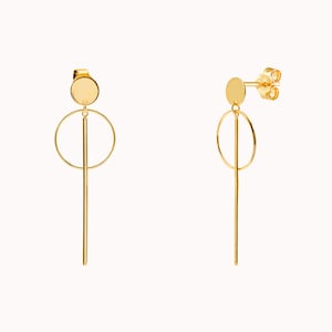 May include: A pair of gold-toned earrings with a circle and a long, thin bar hanging from a small round disc.
