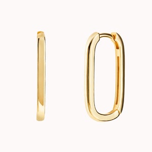 May include: A pair of gold-toned hoop earrings with a rectangular shape. The earrings are made of a smooth metal and have a polished finish.