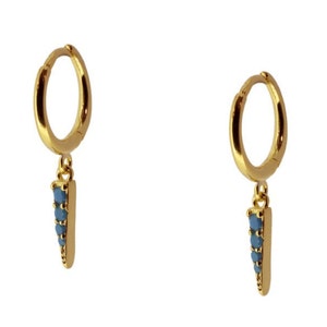 K&ouml;nnte beinhalten: Goldene Creolen mit einem baumelnden blauen Edelstein-Spitzenanh&auml;nger.