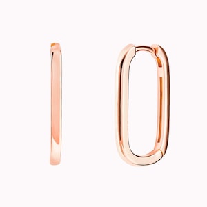 May include: A pair of rose gold hoop earrings with a rectangular shape.