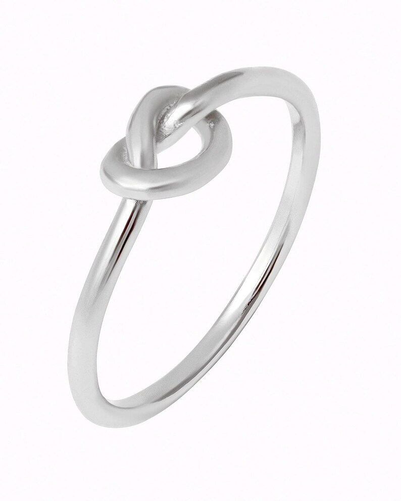 Puede incluir: Un anillo de nudo de plata con un dise&ntilde;o simple.