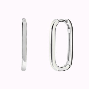 May include: A pair of silver hoop earrings with a rectangular shape.
