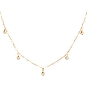 May include: A gold chain necklace with five small gold balls hanging from it.