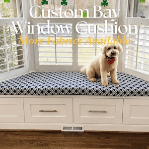 May include: A custom bay window cushion featuring a navy blue and white geometric pattern, placed atop a white built-in storage bench with four drawers and metal handles. The text Custom Bay Window Cushion More Fabrics Available is visible.