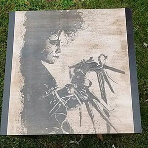 May include: A black and white wood print of a character from the film Beetlejuice. The character is holding a pair of large, sharp scissors.