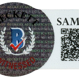 May include: A holographic authentication sticker with the text "BECKETT AUTHENTICATION" and a "B" logo with a checkmark. The sticker also has the word "SAMPLE" and a QR code.