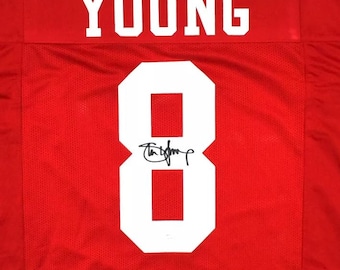 May include: A red jersey with the name "YOUNG" and the number "8" in white. The number is signed in black ink.