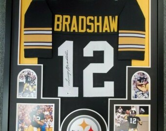 May include: Framed black and gold football jersey with the name "Bradshaw" and the number "12". The frame includes four smaller photos of the player and a Steelers logo.
