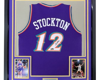 May include: A framed purple basketball jersey with the name "STOCKTON" and the number "12" on the back. The jersey is signed by John Stockton. The frame includes two smaller photos of Stockton playing basketball.