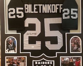 May include: A framed black and silver football jersey with the name "Biletnikoff" and the number "25" on the back. The jersey is signed by the player and includes photos of the player in action.