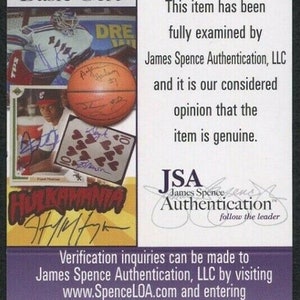 Puede incluir: Certificado de autenticaci&oacute;n James Spence (JSA) morado y blanco. El certificado incluye el texto &laquo;SAMPLE&raquo; y &laquo;Basic Cert&raquo;. Presenta im&aacute;genes de una pelota de baloncesto, un jugador de hockey y una carta. El logotipo de JSA es visible.