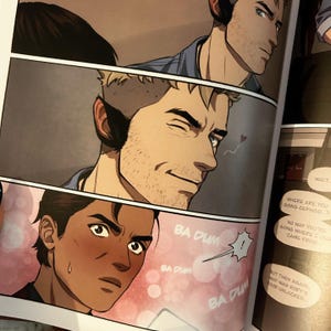 K&ouml;nnte beinhalten: Ein Comic-Panel mit zwei Charakteren. Der Charakter links hat braune Haut und err&ouml;tet. Der Charakter rechts hat helle Haut und zwinkert. Der Text im Panel lautet "BA DUM" und "WARTEN".
