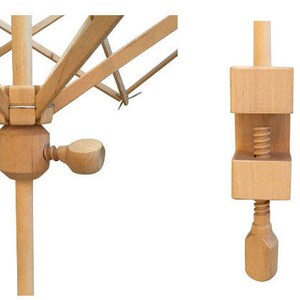 May include: A wooden knitting loom with a crank handle. The loom is made of natural wood and has a circular shape. The loom is folded up and ready to be used.