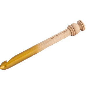 May include: A wooden crochet hook with a gold-colored tip. The hook is 9.5 mm and is labeled "Pony #10 9.5 mm".