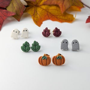 May include: A set of six pairs of polymer clay earrings featuring various fall and Halloween themes. The earrings include pumpkins, leaves, and ghosts.