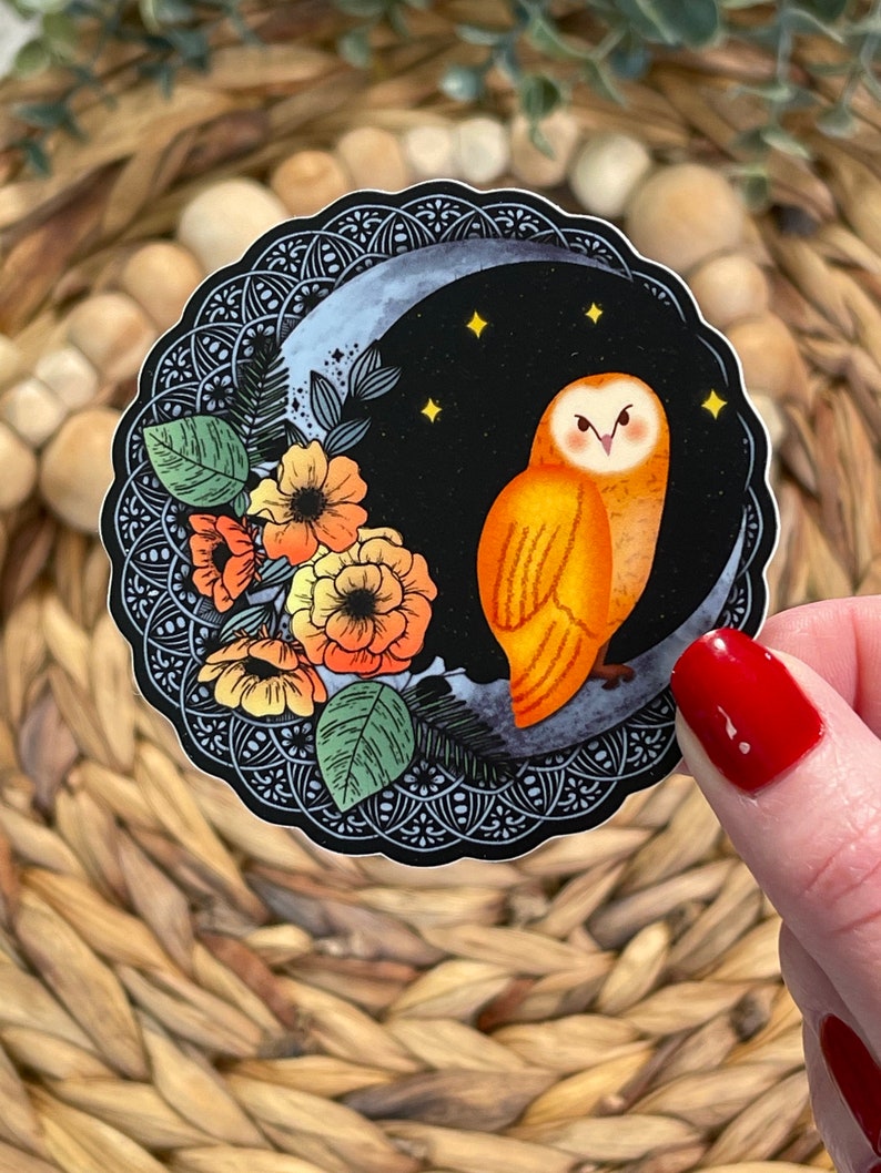 Pu&ograve; includere: Un adesivo con un'illustrazione stilizzata di un gufo arancione appollaiato su una luna crescente su sfondo nero. Il gufo &egrave; circondato da fiori arancioni e gialli e foglie verdi. La luna &egrave; decorata con un motivo mandala in bianco e nero.