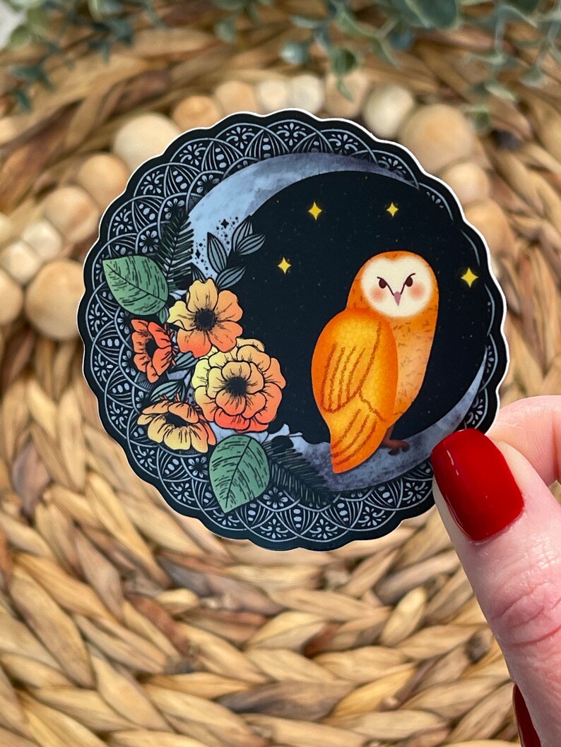 Pu&ograve; includere: Un adesivo con un'illustrazione stilizzata di un gufo arancione appollaiato su una luna crescente con un design floreale. Il gufo ha grandi occhi rotondi e un motivo di piume dettagliato. La luna &egrave; circondata da un design simile a un mandala in bianco e nero.