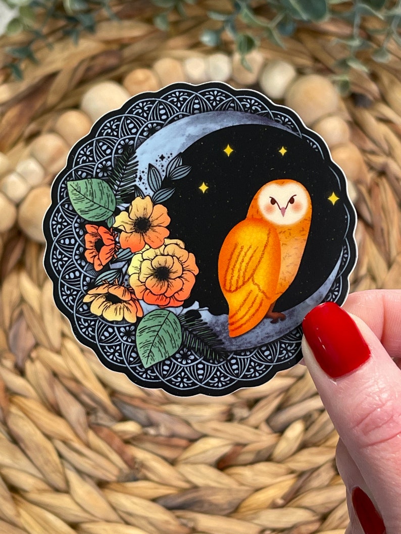 Pu&ograve; includere: Un adesivo con un'illustrazione stilizzata di un gufo arancione appollaiato su una luna crescente su sfondo nero. Il gufo ha grandi occhi gialli e un design dettagliato. La luna &egrave; circondata da un motivo mandala bianco e nero e da alcune piccole stelle gialle. Ci sono anche fiori arancioni e gialli sul lato sinistro dell'adesivo.